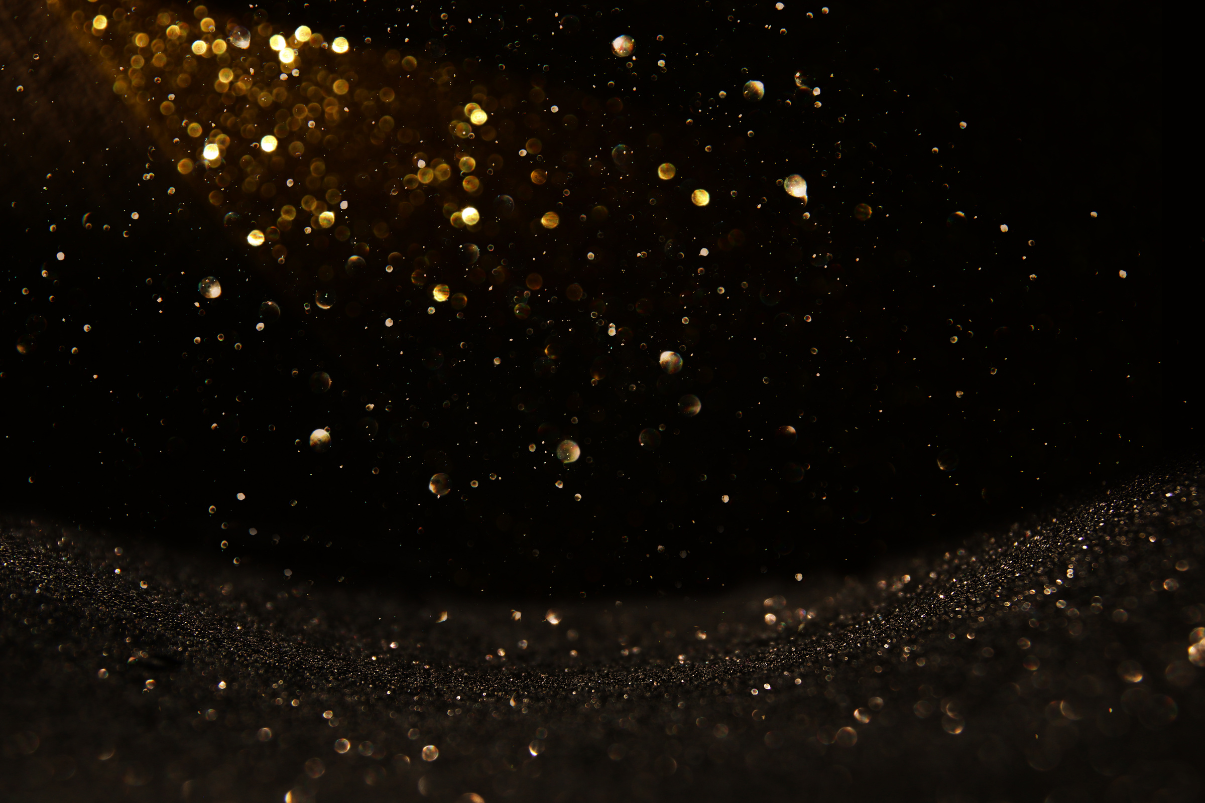 glitter vintage lights background. black and gold. de-focused.